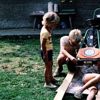 Children playing with homemade toy race car.