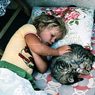 Child and cat peacefully sleeping together.