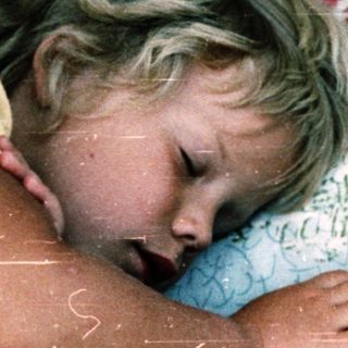 Child and cat peacefully sleeping together.