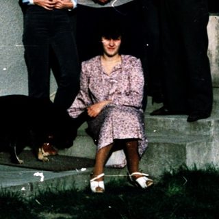 Family group posing outside a house with dog.