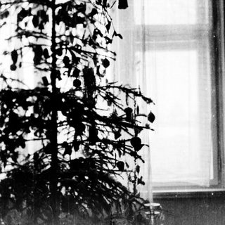 Vintage Christmas tree beside window.