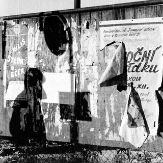 Peeling wall with old political posters and graffiti.