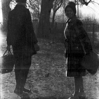 Two people walking on a path in a park.