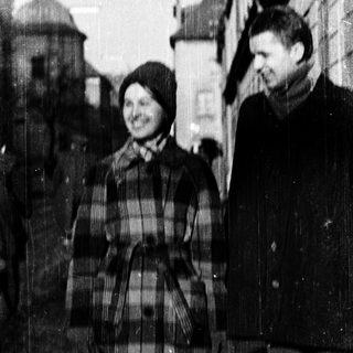 Two people smiling outdoors in winter attire.