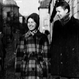 Two people smiling outdoors in winter attire.