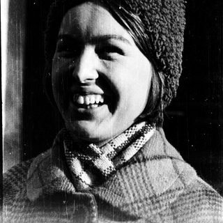 Smiling person wearing knit hat and scarf.