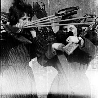 Two women playing double basses in a band.