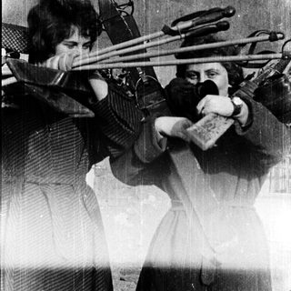 Two women playing double basses in a band.