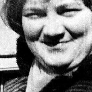 Smiling person in striped sweater, black-and-white photo.