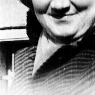 Smiling person in striped sweater, black-and-white photo.