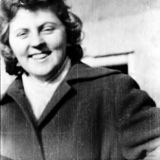 Smiling woman in vintage clothing, mid-20th century.