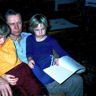 Family indoors studying or reading together.