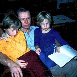 Family indoors studying or reading together.