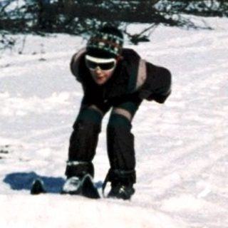 Person cross-country skiing in snowy residential area.