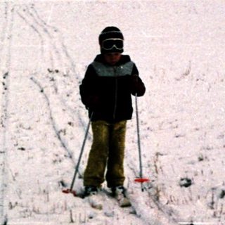 Person cross-country skiing on snow-covered trail.
