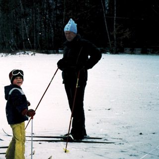 Three people cross-country skiing on snow-covered ground.
