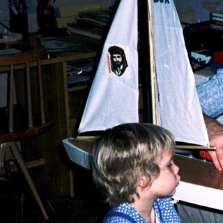 Man and child assembling a model sailboat together.