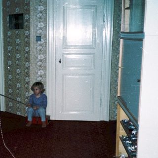 Child playing with toy on red carpet.