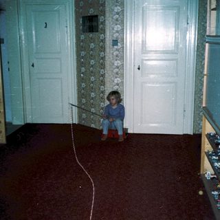 Child playing with toy on red carpet.