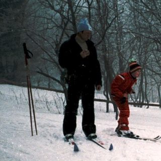People skiing on snowy slope with instructor.