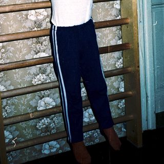 Young boy doing pull-ups on wooden ladder.
