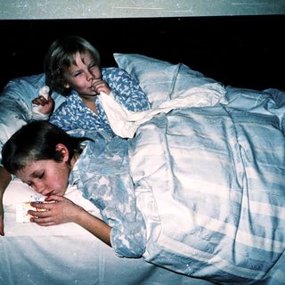 Two children resting in bed together.