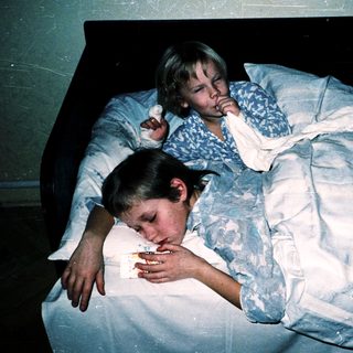 Two children resting in bed together.
