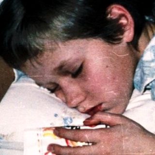 Two children resting in bed together.