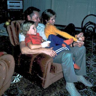 Family watching television indoors together.