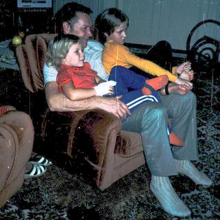 Family watching television indoors together.