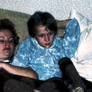 Family resting together on a bed.