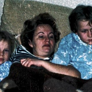 Family resting together on a bed.