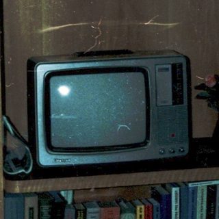 Vintage wooden cabinet with old photos, cassette tapes, and CRT TV.