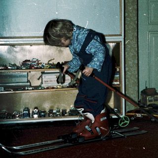 Child playing with toy cars indoors.