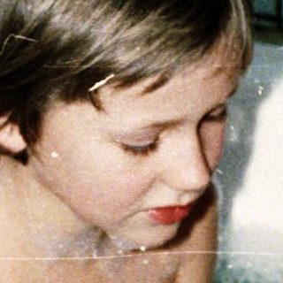 Two children playing in a bathtub with bubbles.