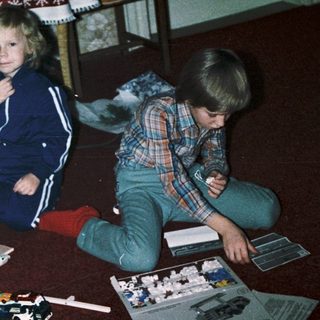 Two children building model kits indoors.