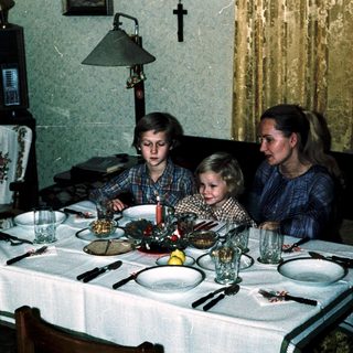 Family dining together indoors during evening meal.