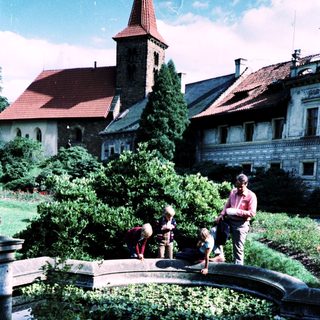 Family near historic fountain in landscaped courtyard.