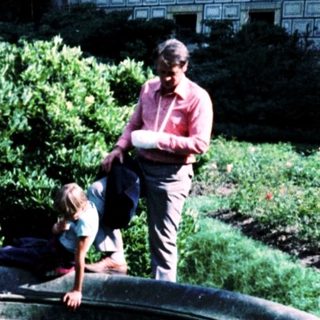 Family near historic fountain in landscaped courtyard.