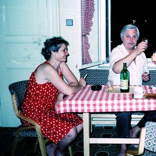 Three people enjoying a meal and drinks indoors.