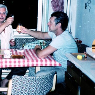 Three people enjoying a meal and drinks indoors.