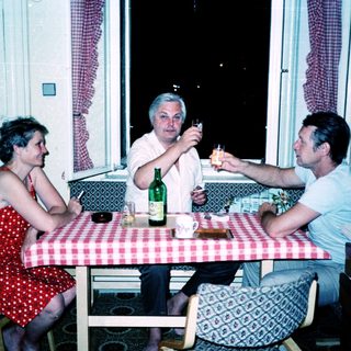Three people enjoying a meal and drinks indoors.