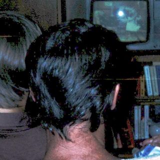 Three people watching old CRT TV together.