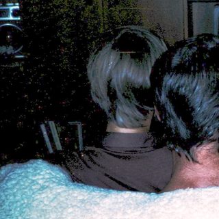 Three people watching old CRT TV together.