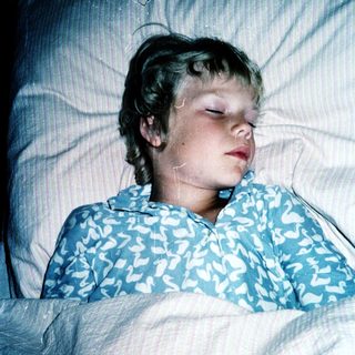 A child peacefully sleeping in bed.