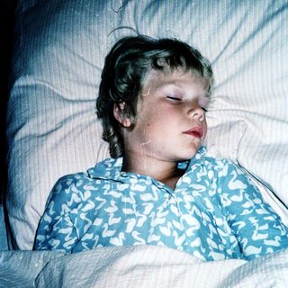 A child peacefully sleeping in bed.
