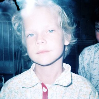 Two children posing indoors, mid-20th century style.