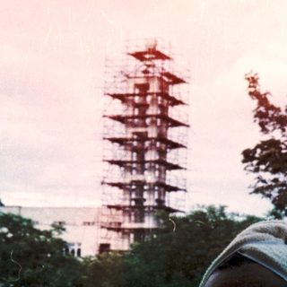 Person in traditional attire views pagoda at dusk.