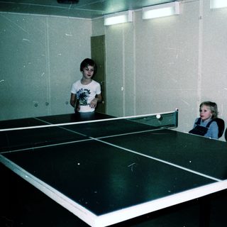 Family playing indoor table tennis together.