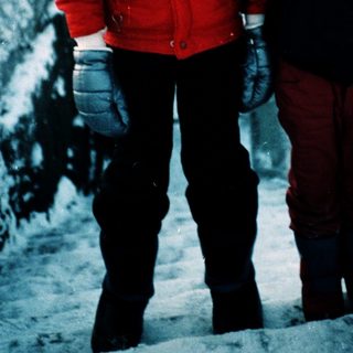 Two children playing in snow with snow tools.